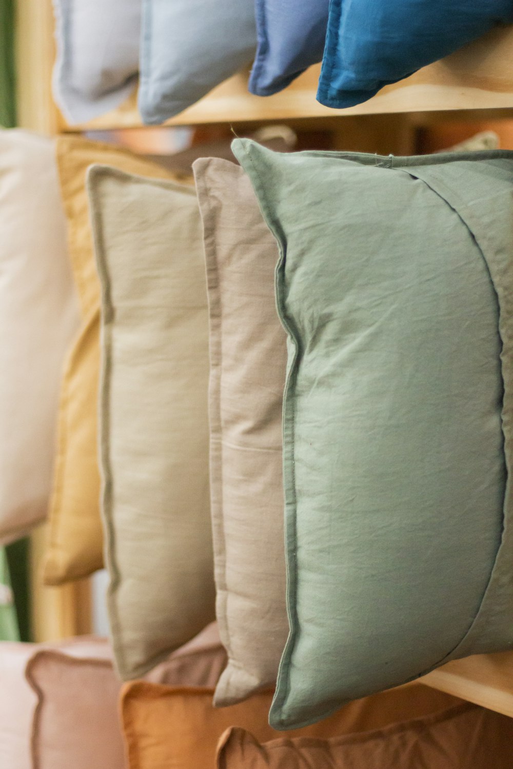 a row of pillows sitting on top of a wooden shelf