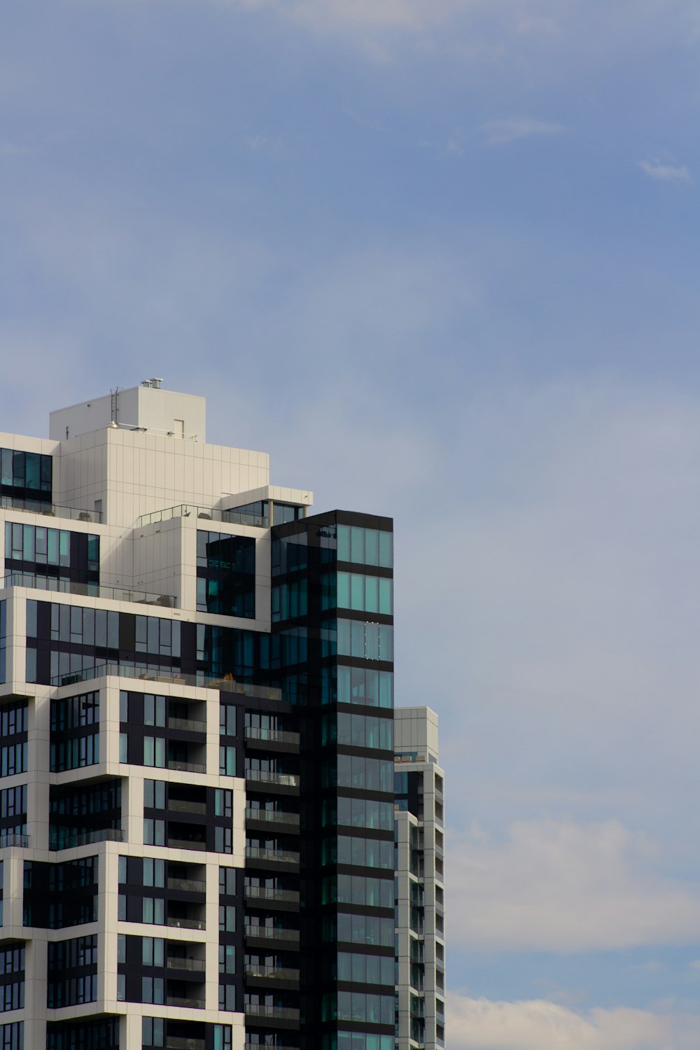 a plane flying in the sky over a tall building