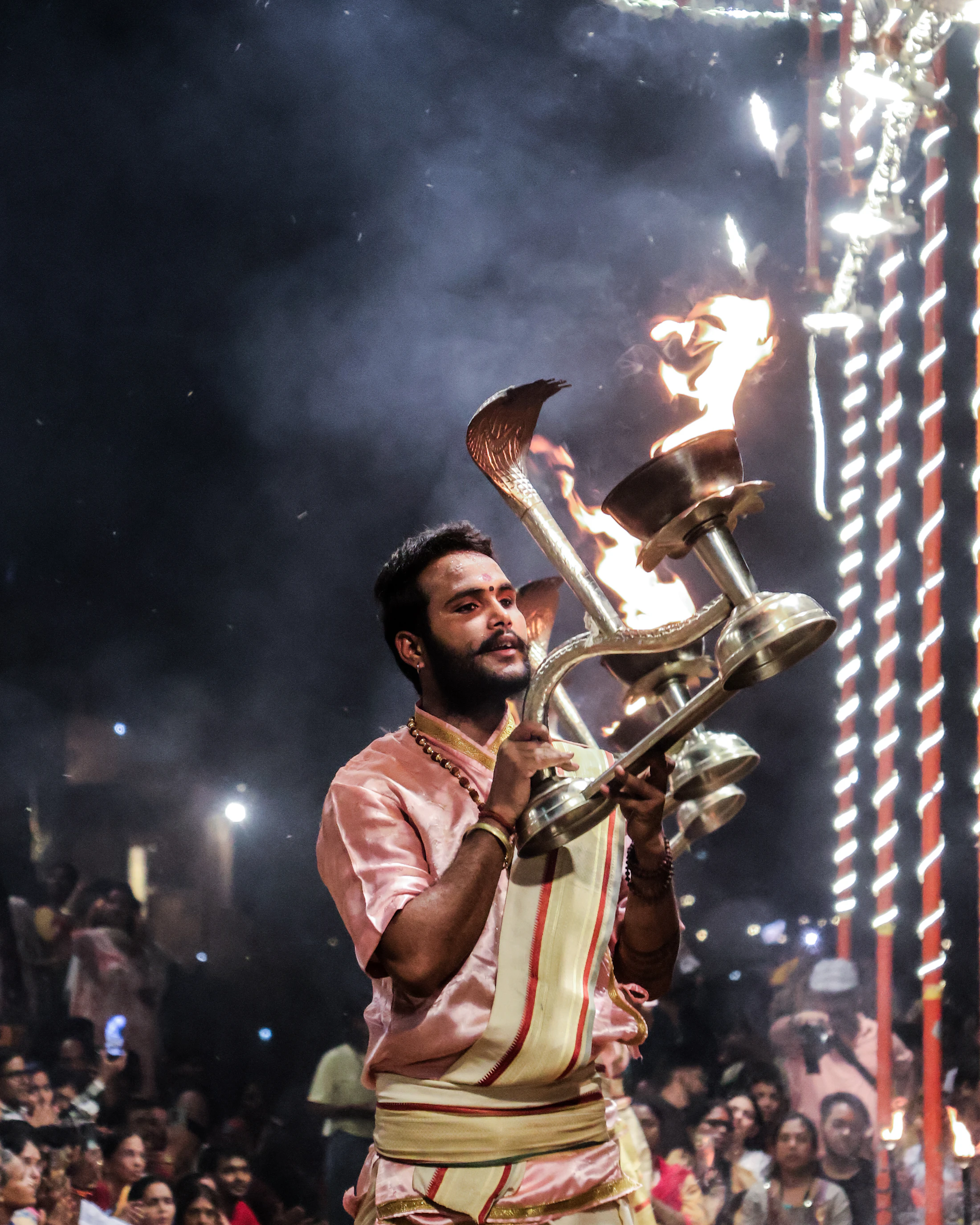 A priest raising a flaming lamp during the Ganga Aarti at Assi Ghat