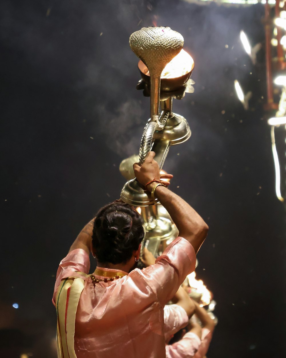a man in a pink outfit holding a golden trophy