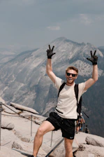 a man standing on top of a mountain with his hands in the air