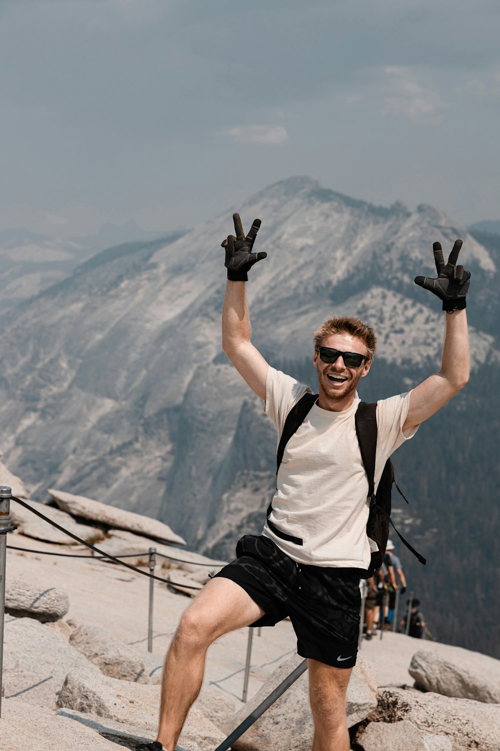 a man standing on top of a mountain with his hands in the air