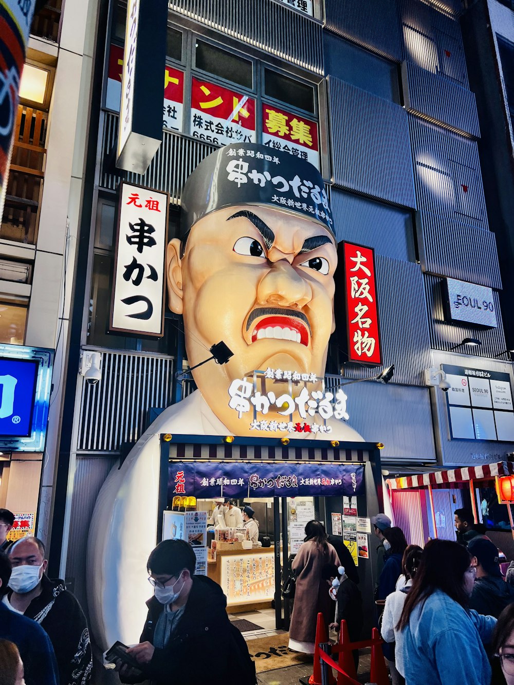 a large statue of a man in a hat on the side of a building