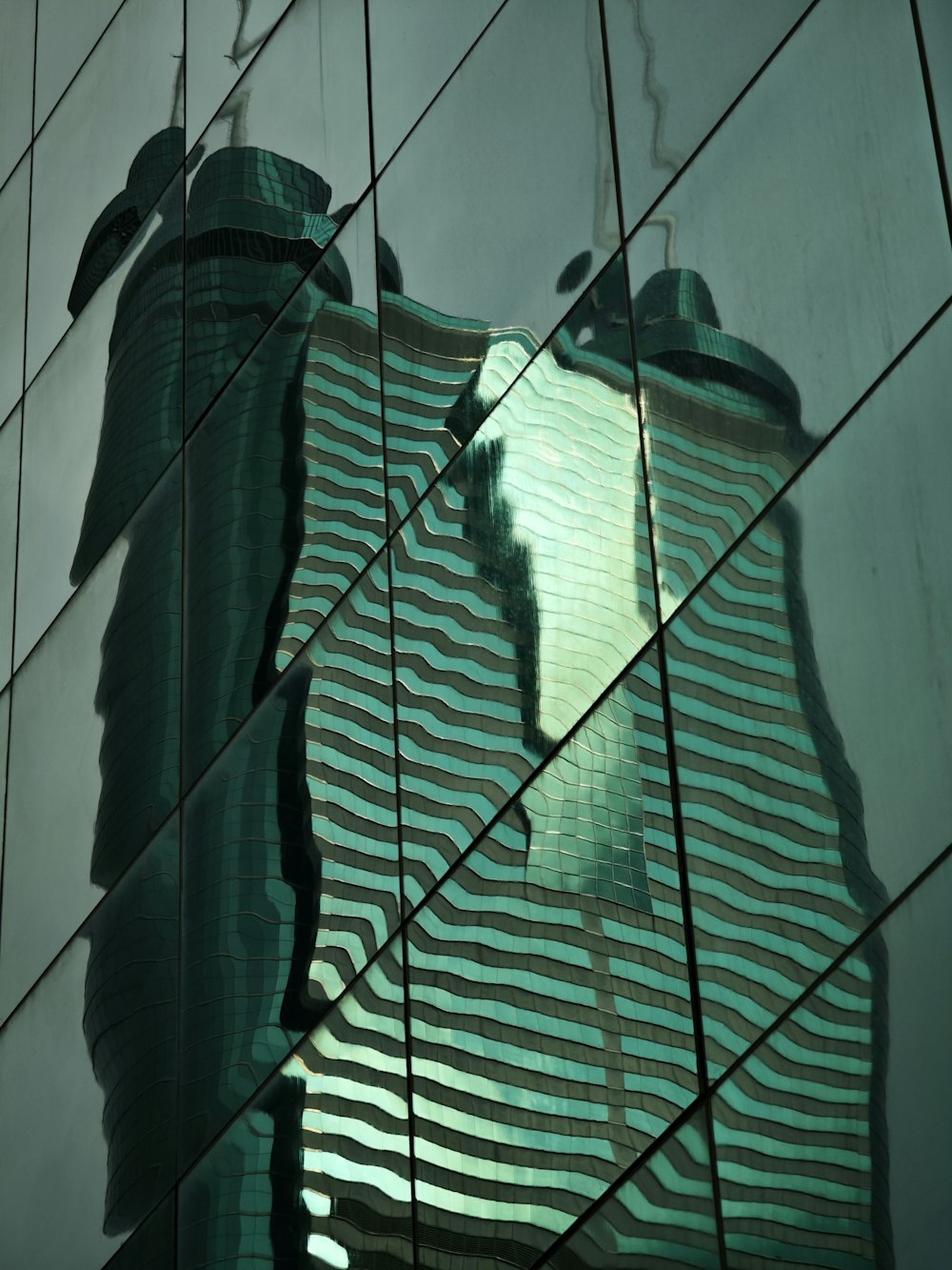 the reflection of a building in the glass of another building