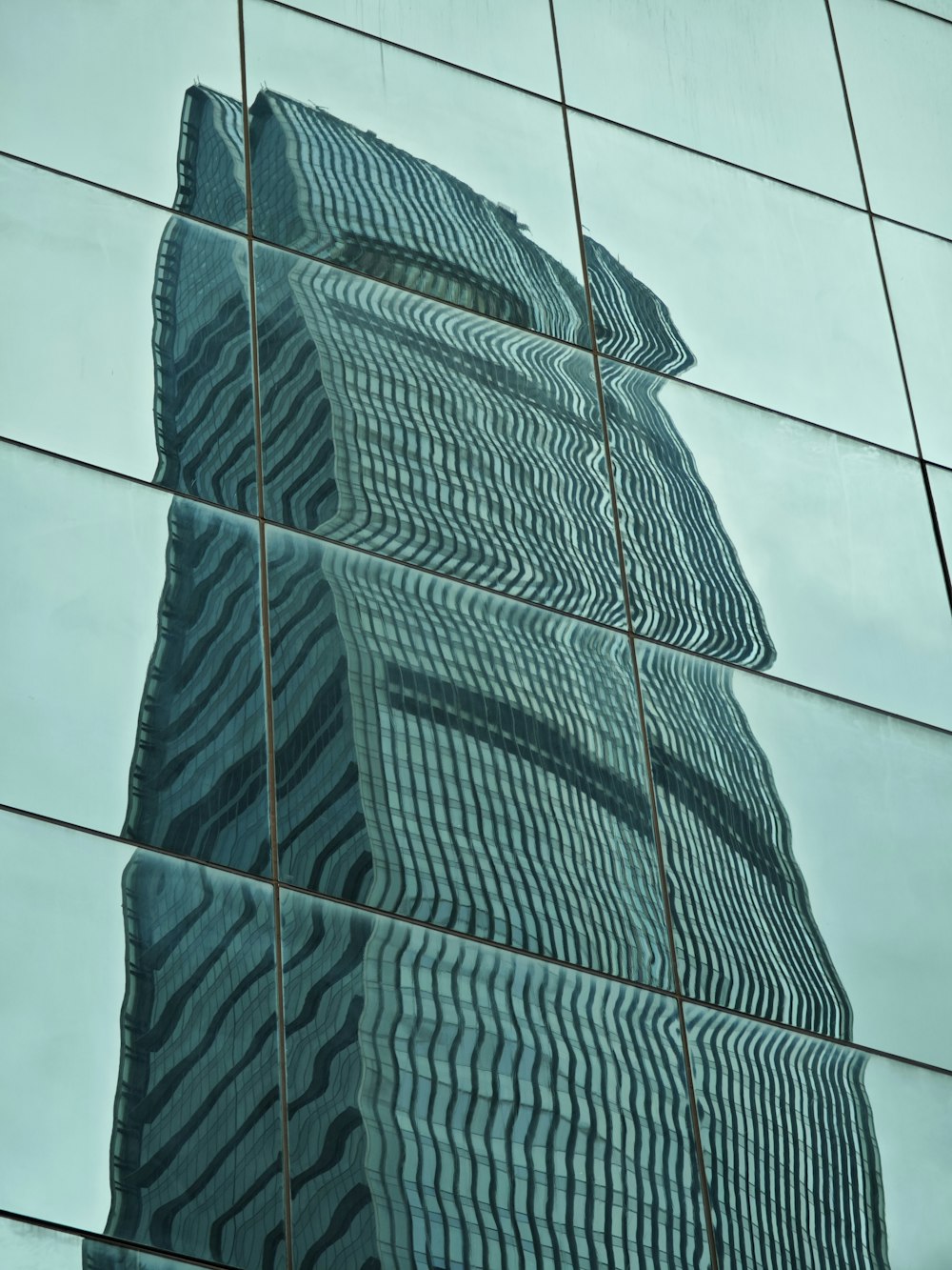 the reflection of a building in the glass of another building
