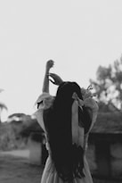 a woman in a dress reaching up into the air