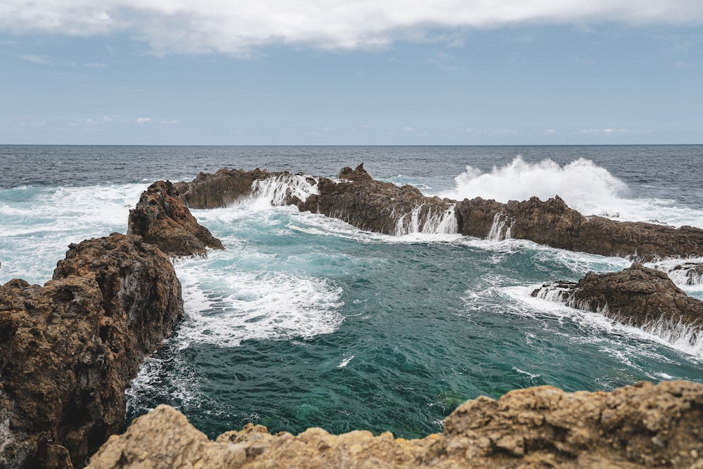 a view of the ocean from a rocky shore