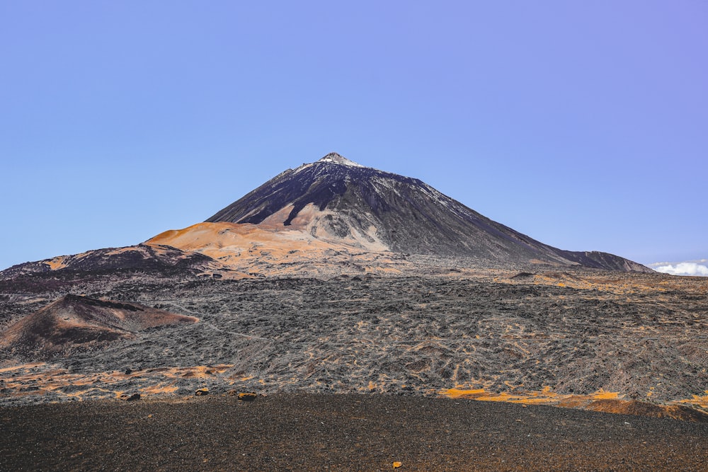 a very tall mountain with a blue sky in the background