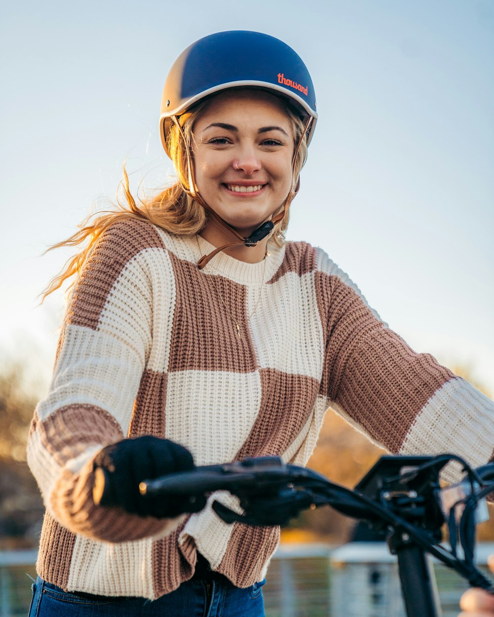 a woman wearing a helmet is riding a bike