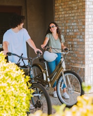 a man standing next to a woman on a bike