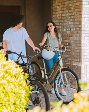 a man standing next to a woman on a bike