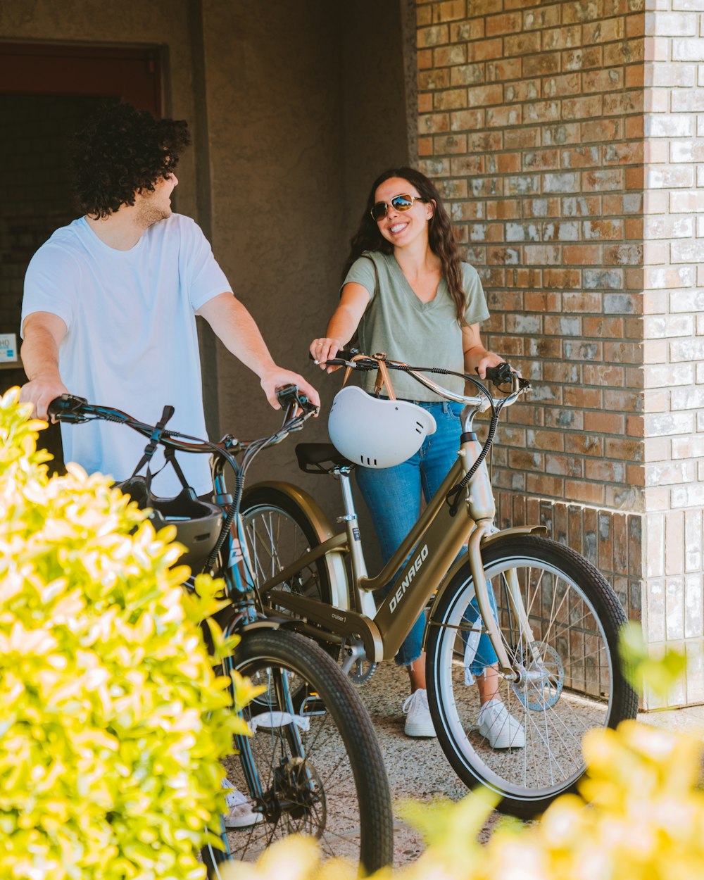 a man standing next to a woman on a bike