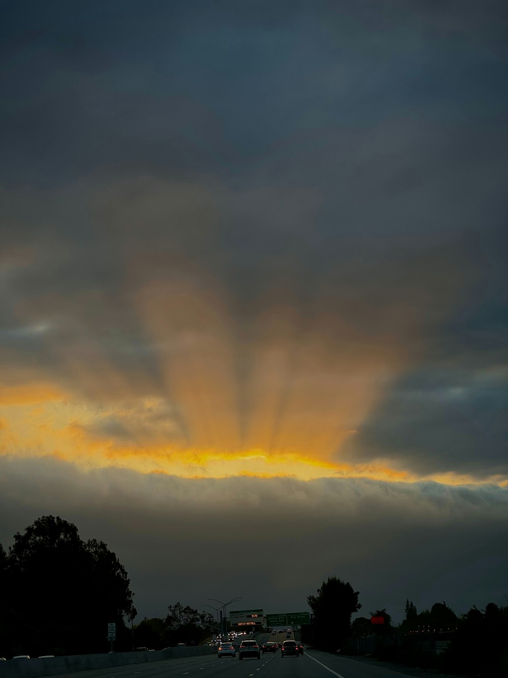 the sun is shining through the clouds over the road