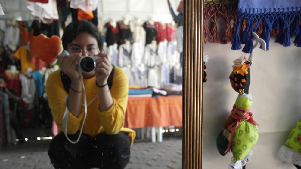 a woman taking a picture of herself in a mirror