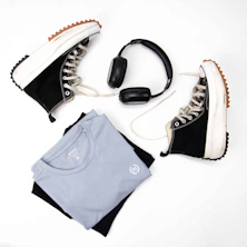 a pair of sneakers, headphones, and a t - shirt are laid out