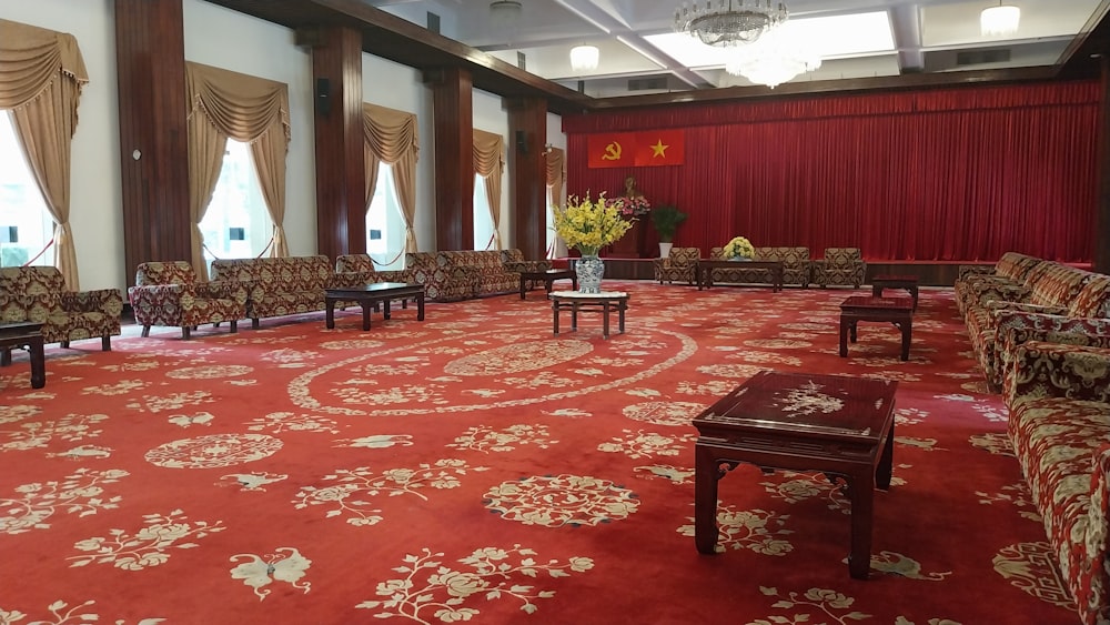 a large room with a red carpet and chairs