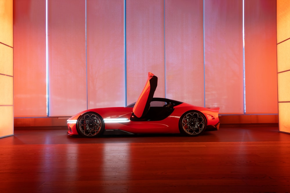 a red sports car parked in front of a wall