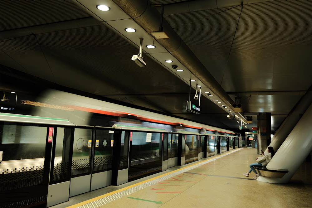 a person sitting on a bench in a train station