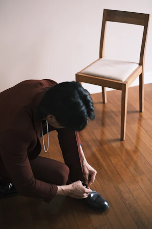 a woman kneeling down on the floor next to a chair