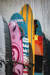 a bunch of surfboards are lined up against a wall