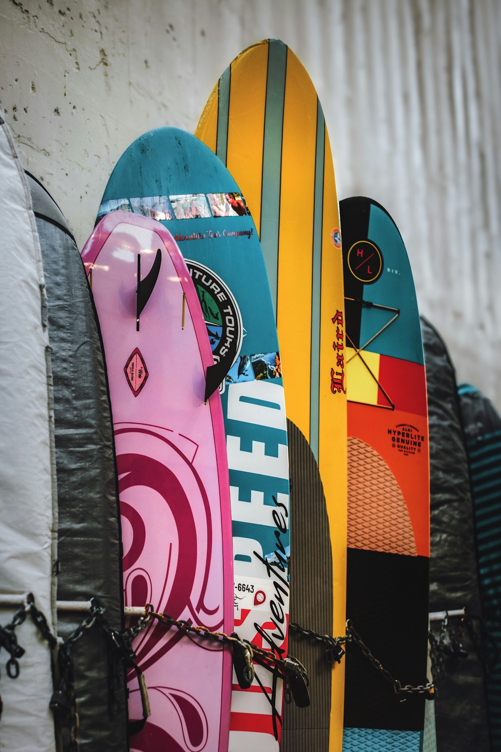 a bunch of surfboards are lined up against a wall