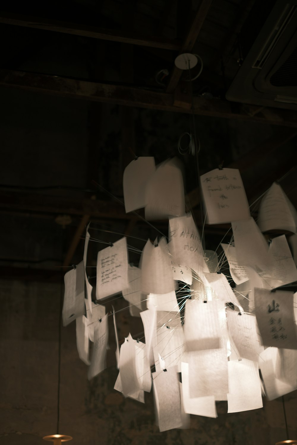 a chandelier made out of paper notes hanging from the ceiling