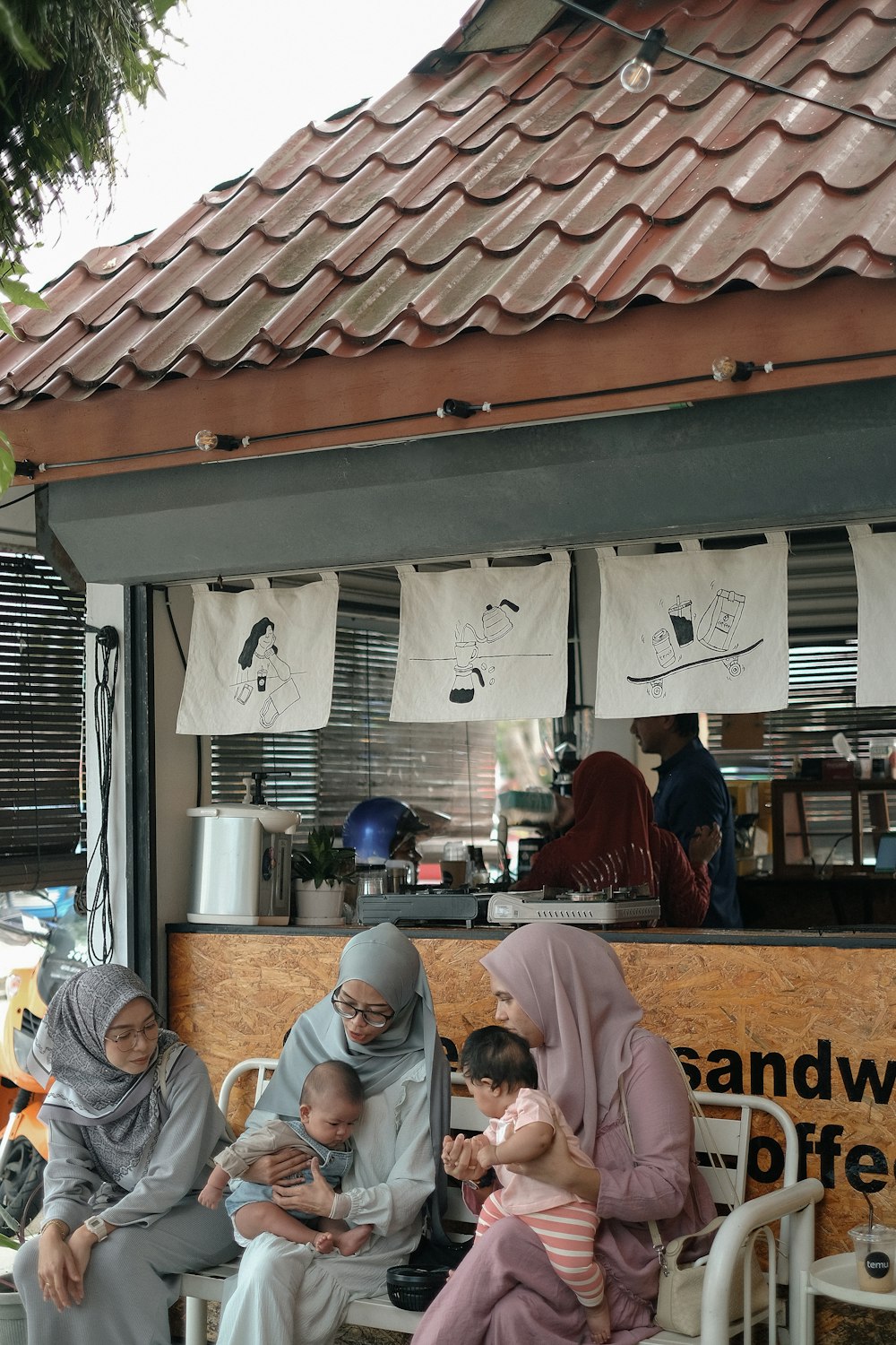 a group of people sitting around a food stand