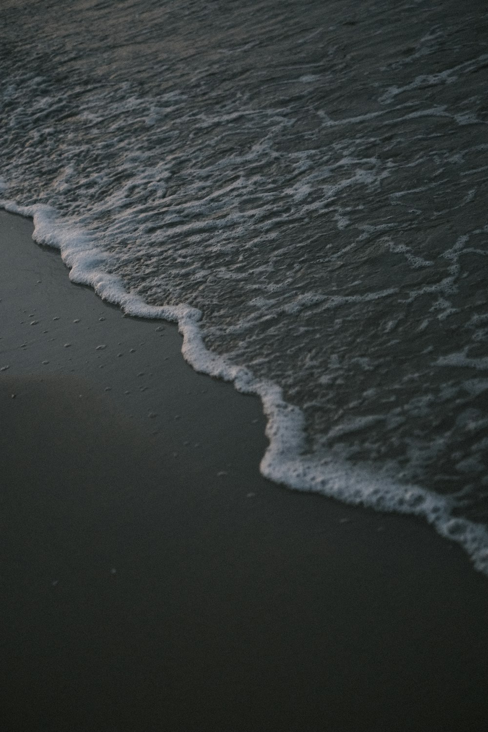 a person walking along a beach next to the ocean