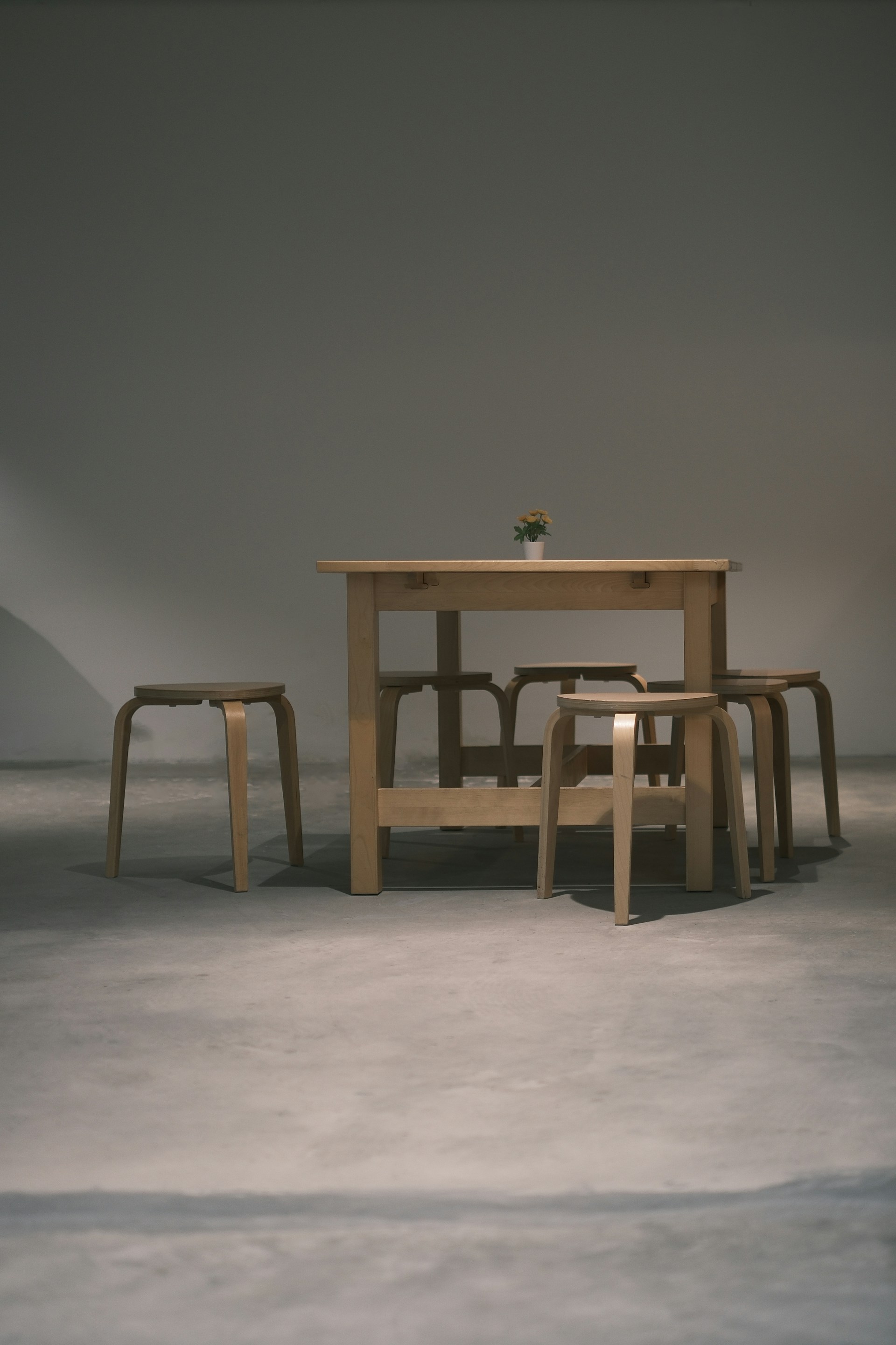 a wooden table and four stools in a room