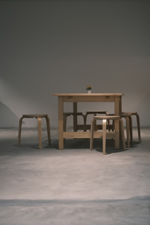 a wooden table and four stools in a room