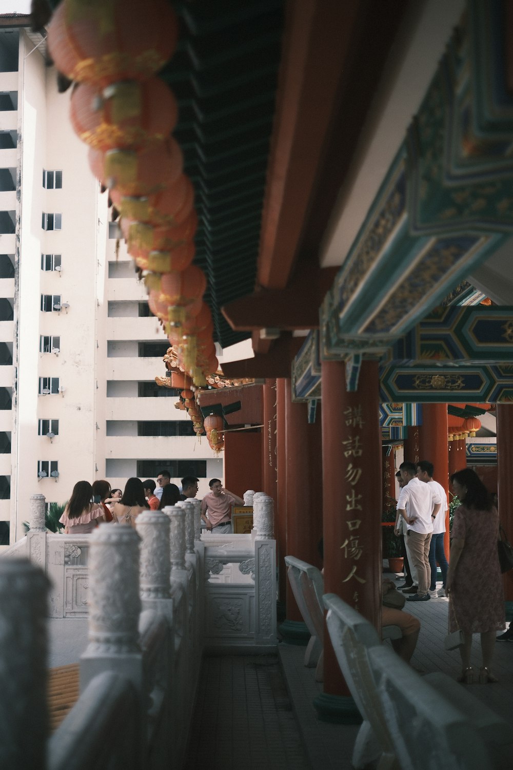 a group of people standing on a balcony next to tall buildings