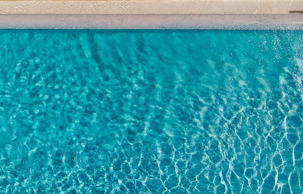 an aerial view of a pool with blue water