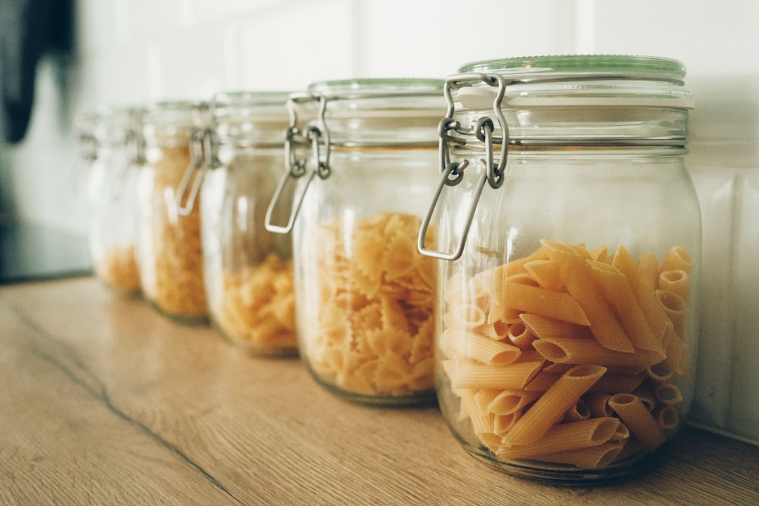 Jars with pasta in a row on kitchen table