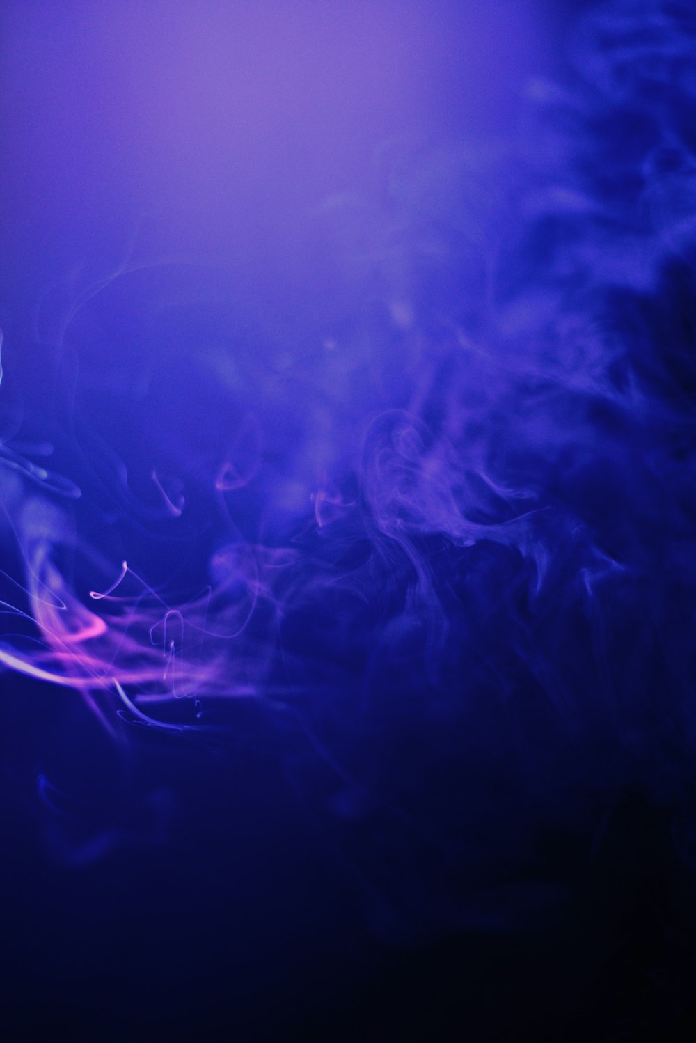 a blue and purple background with smoke coming out of it
