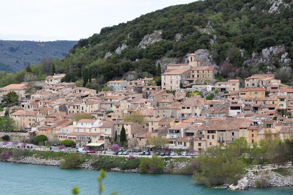 a village on the side of a mountain next to a body of water