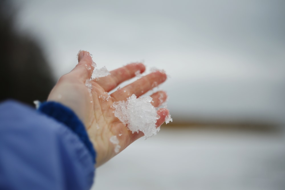 a person holding out their hand with snow on it