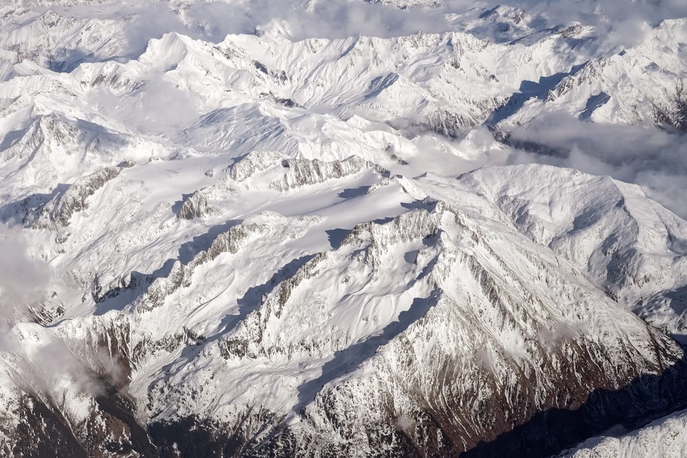 an aerial view of a mountain range covered in snow