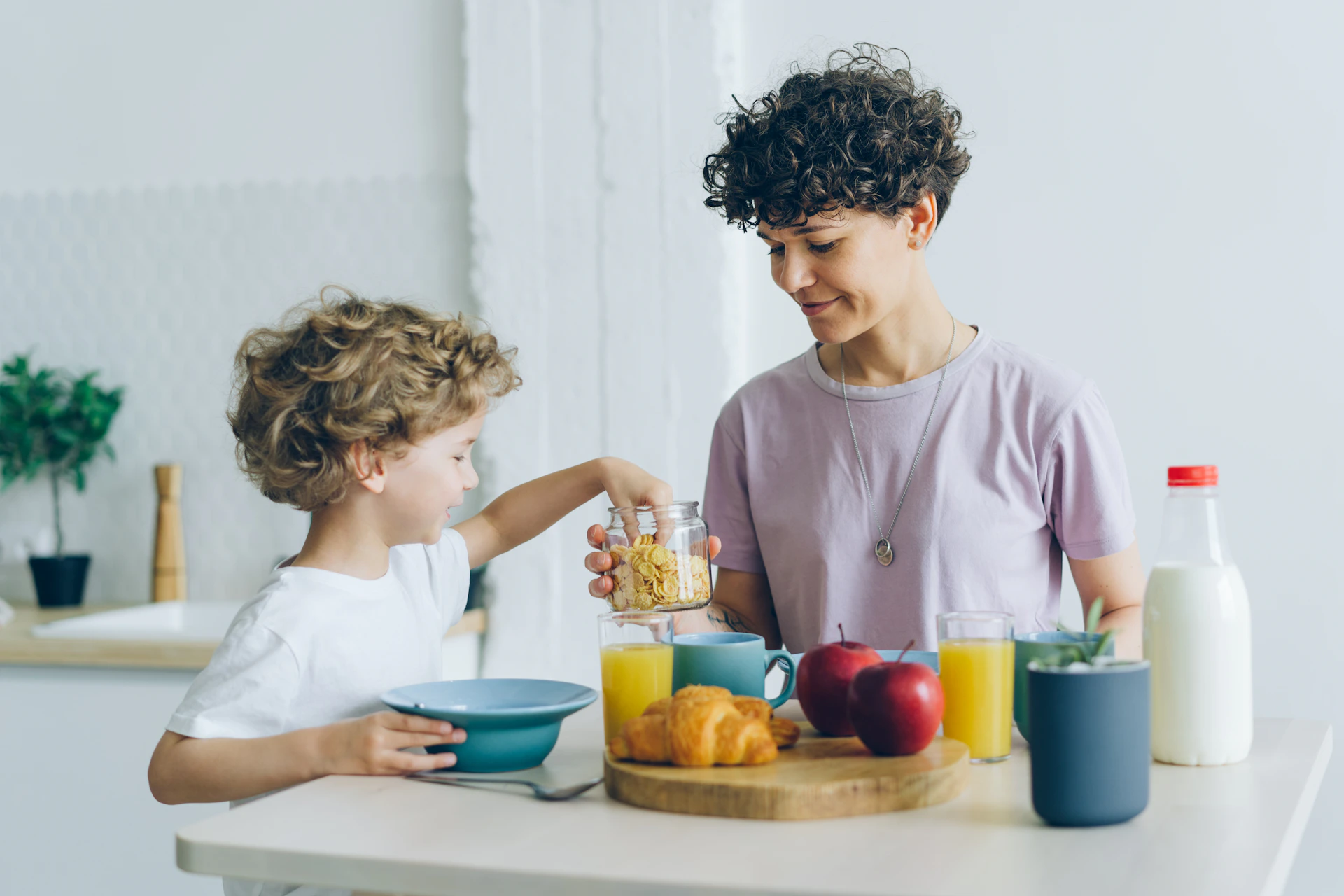 a woman and a child are having breakfast together