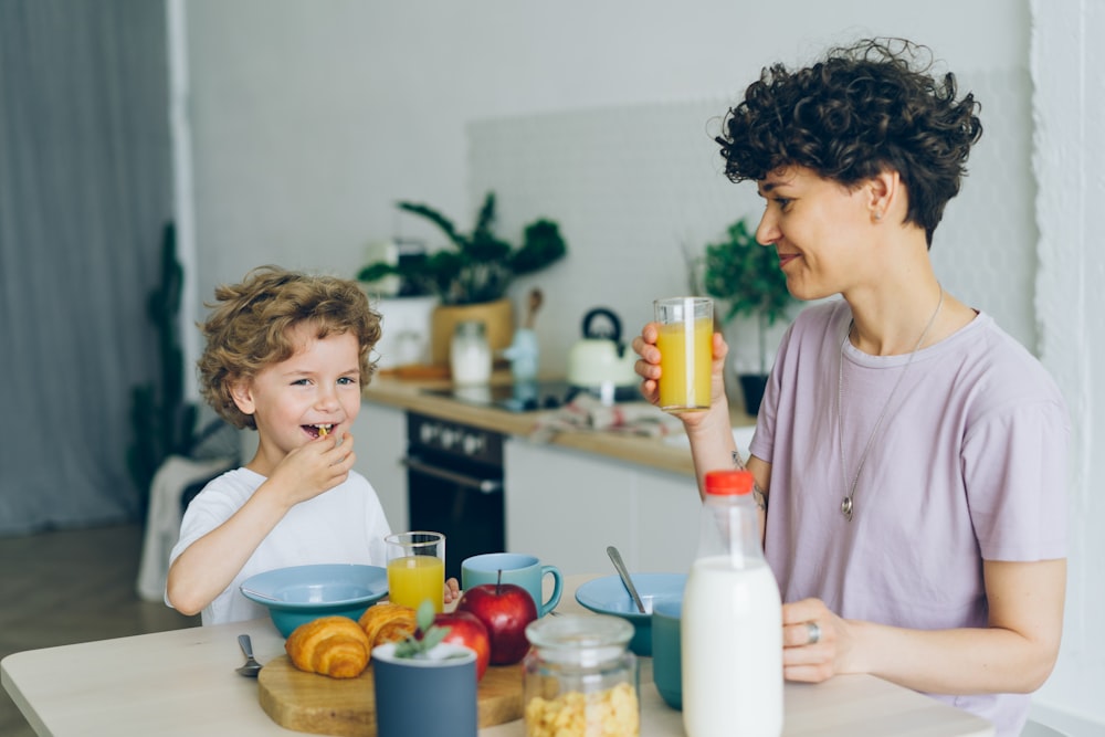 a woman and a child sitting at a kitchen table