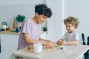 a woman and a child are making cookies