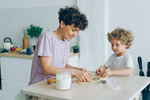 a woman and a child are making cookies