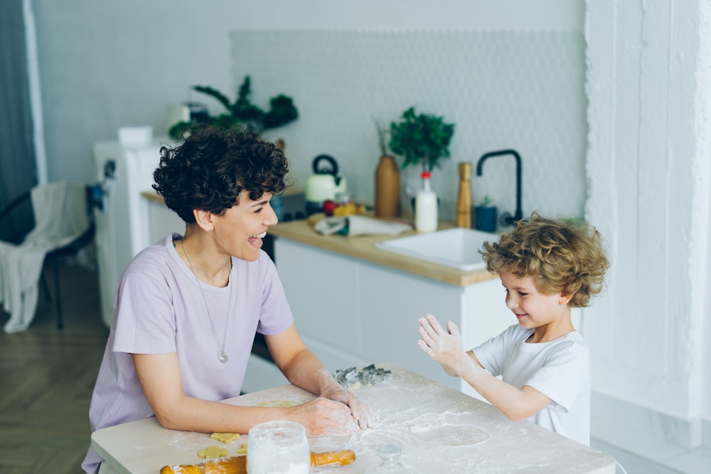 a woman and a child sitting at a kitchen table