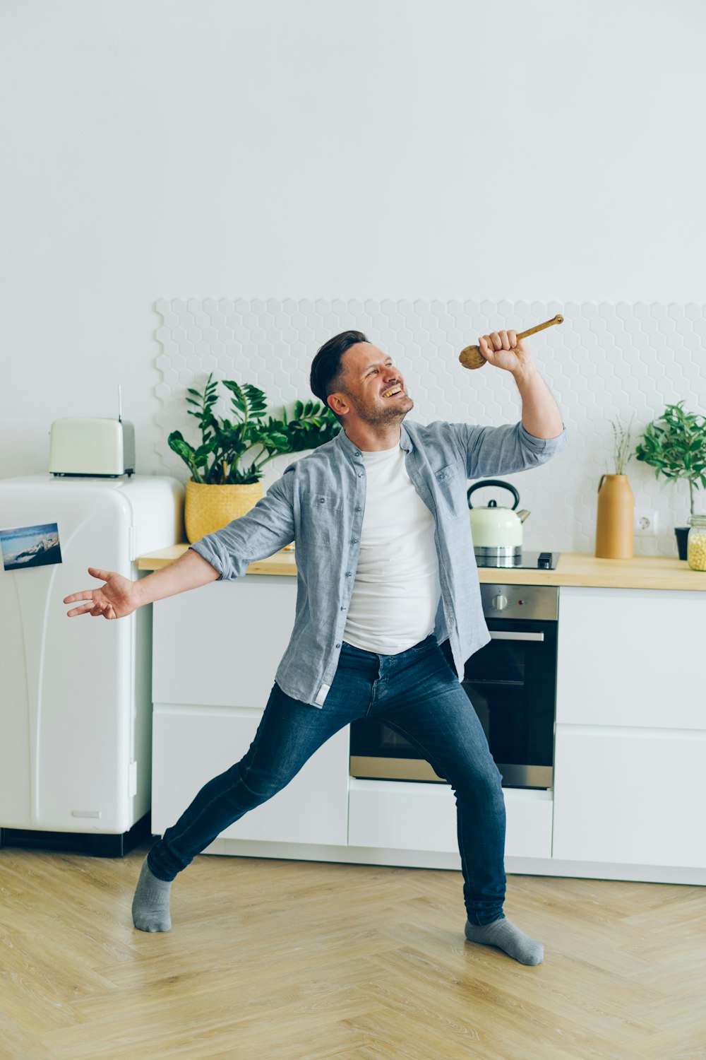 a man standing on a hard wood floor in a kitchen