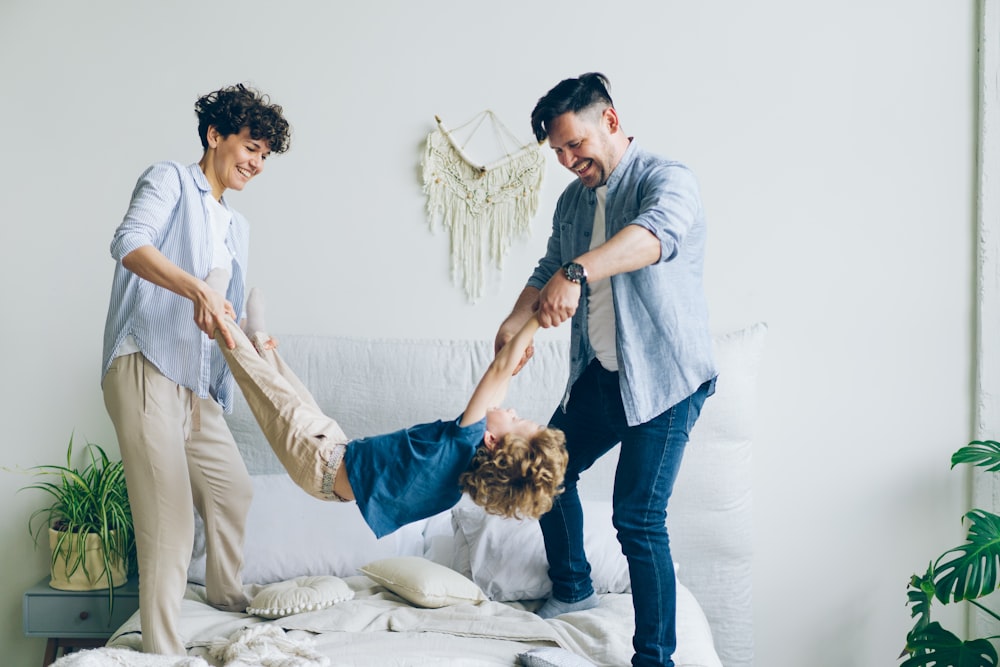 a man and a woman playing with a child on a bed