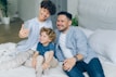 a man and two children sitting on a bed
