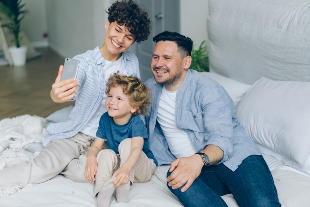 a man and two children sitting on a bed