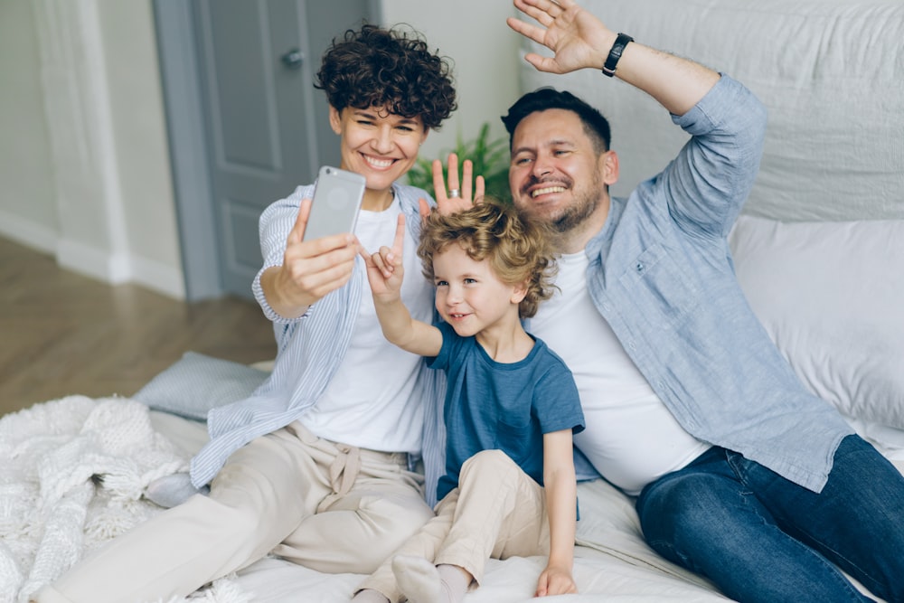 a man and two children sitting on a bed