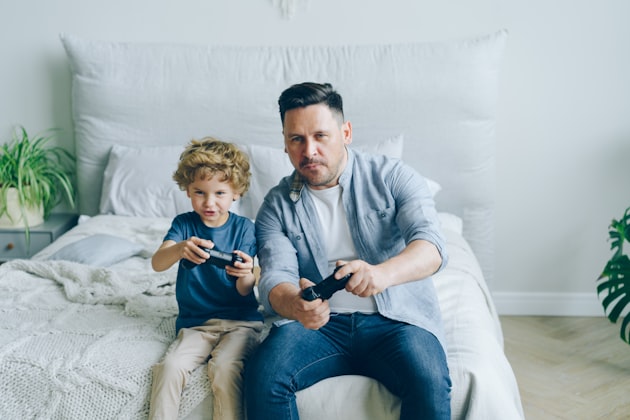 Parent et enfant jouant ensemble aux jeux vidéo