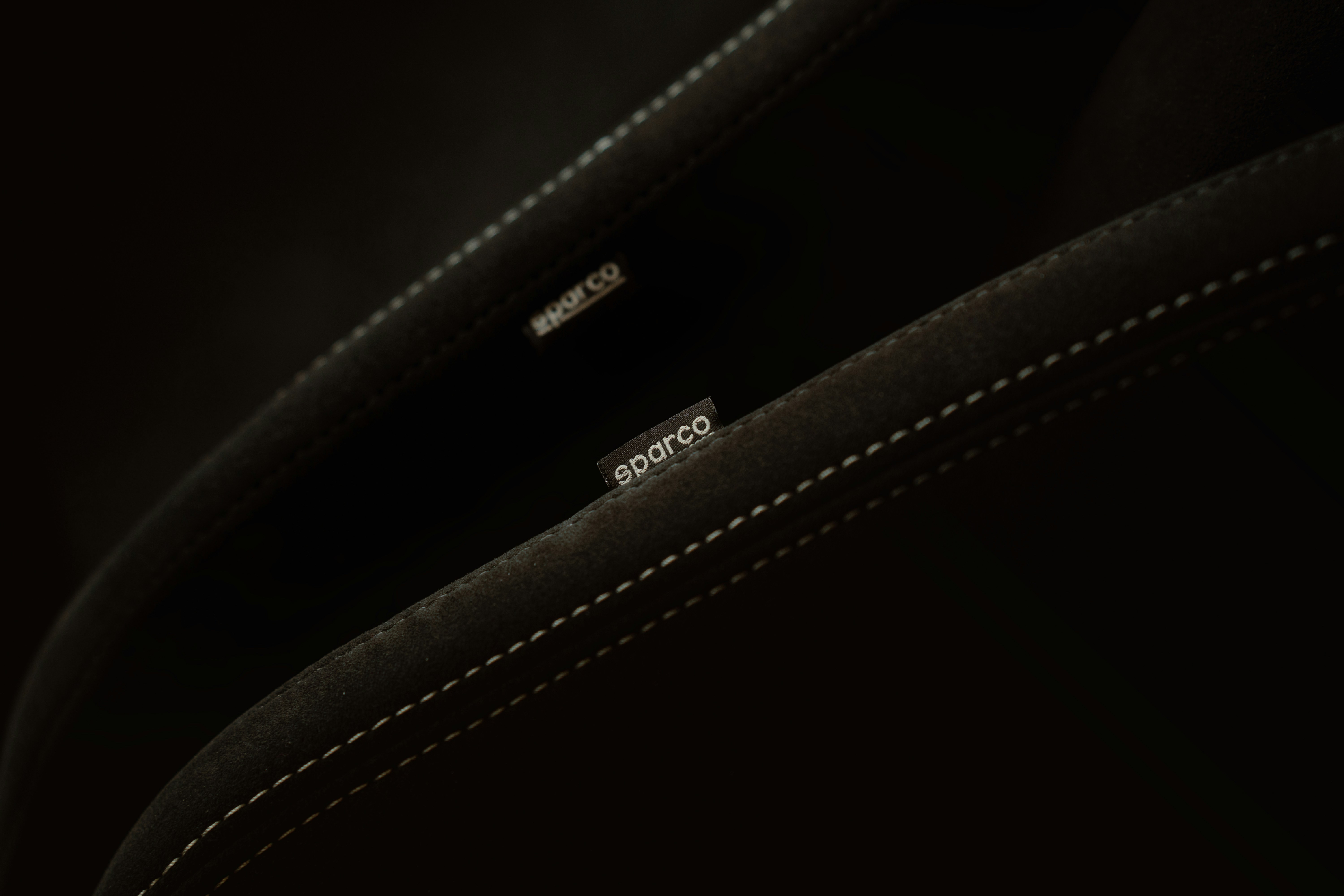 a close up of a black bag with white stitching