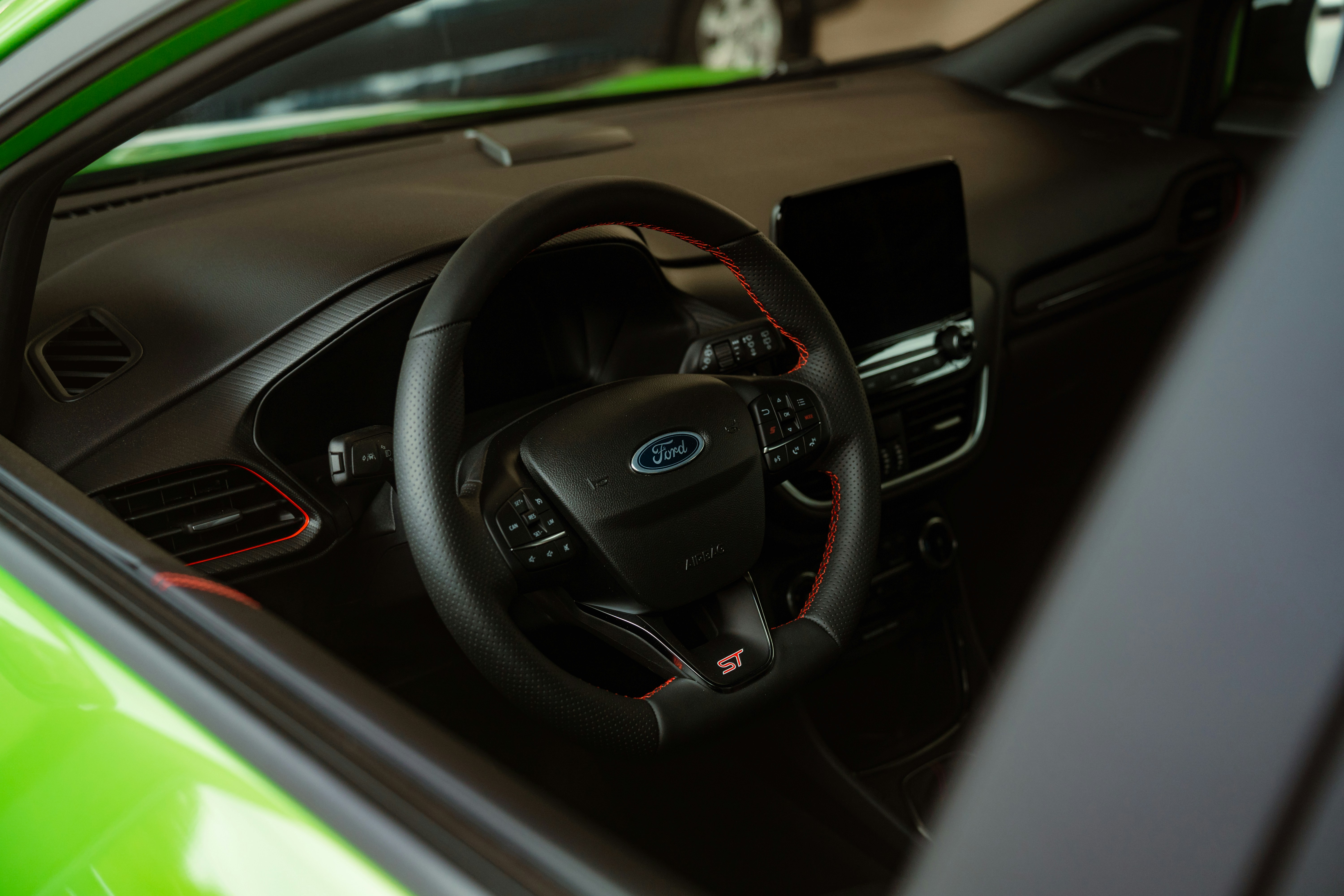 the interior of a green car with a steering wheel